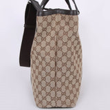 Beige GG canvas tote bag with brown leather trim and shoulder strap, side view showing monogram pattern — Gucci | Endless UAE