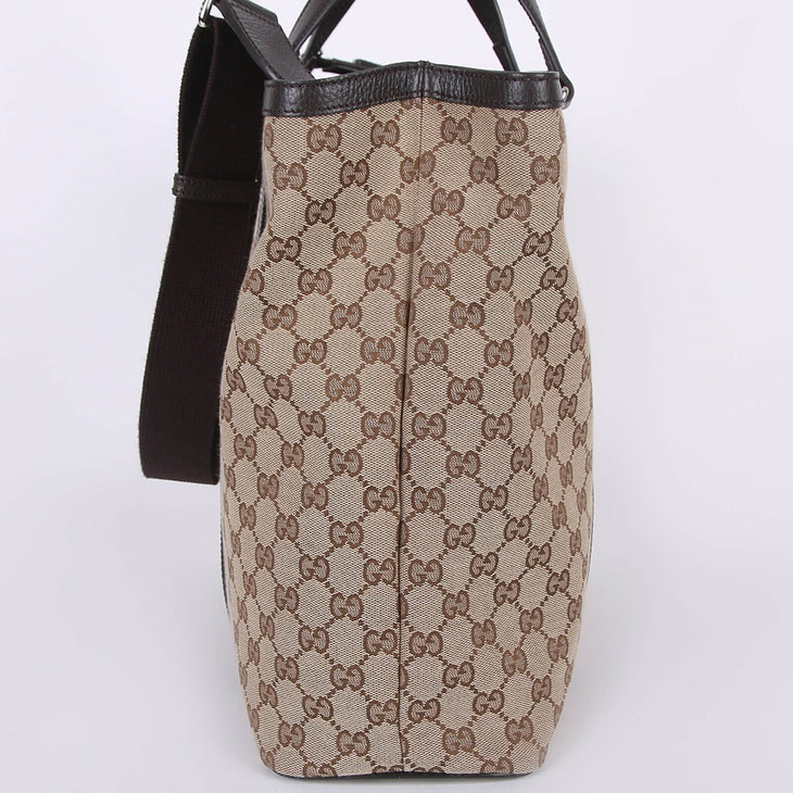 Beige GG canvas tote bag with brown leather trim and shoulder strap, side view showing monogram pattern — Gucci | Endless UAE