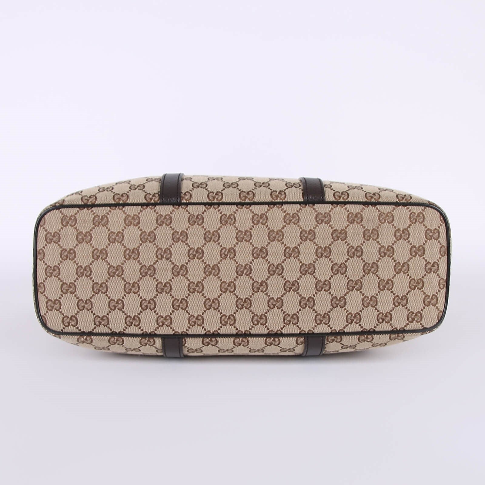 Bottom view of beige GG monogram canvas tote bag with brown leather trim and protective feet — Gucci | Endless UAE