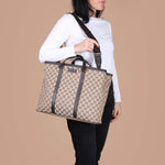 Woman wearing beige GG monogram canvas tote bag with brown leather trim and adjustable shoulder strap — Gucci | Endless UAE