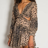 Leopard print dress with long sleeves, deep V-neckline, and cutout waist detail paired with black quilted bag — Zimmermann | Endless UAE