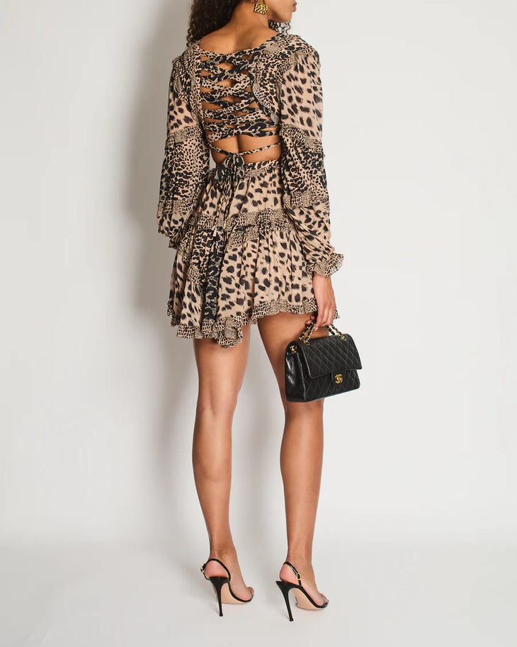 Rear view of woman wearing brown leopard print dress with ruched cutout back detail, long sleeves, and ruffled hem, paired with black heels and handbag — Zimmermann | Endless UAE