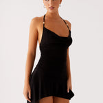 Black halter mini dress with ruched bodice and asymmetrical hem worn by model — Peppermayo | Endless UAE