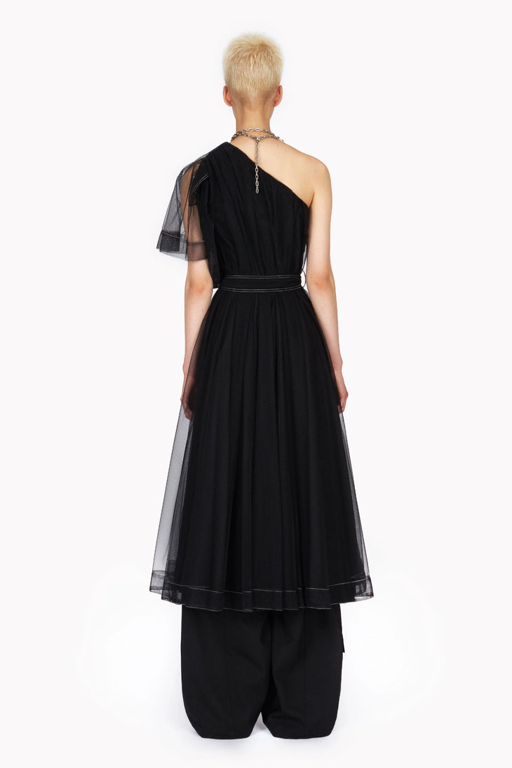 Black asymmetric one shoulder tulle trench dress with sheer overlay and chain detail shown from back — Act N1 | Endless UAE