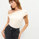 Woman wearing cream off-shoulder Cello Knit Top with black denim skirt and nude heels — Reformation | Endless UAE