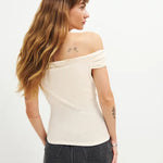 Woman wearing cream off-shoulder Cello Knit Top with black denim skirt and nude heels — Reformation | Endless UAE