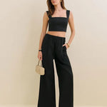 Woman wearing black Fernando linen wide leg pants with matching crop top and sandals — Reformation | Endless UAE