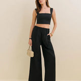 Woman wearing black Fernando linen wide leg pants with matching crop top and sandals — Reformation | Endless UAE