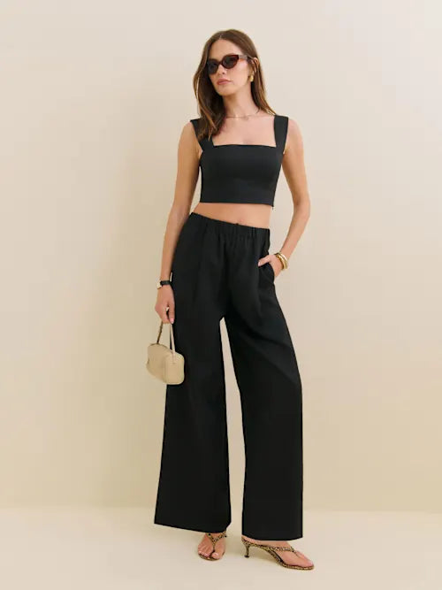 Woman wearing black Fernando linen wide leg pants with matching crop top and sandals — Reformation | Endless UAE