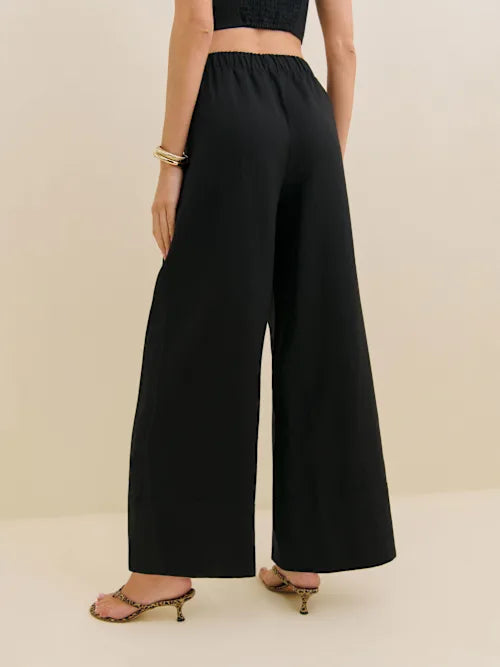 Black linen wide leg pants with elastic waistband shown from back view on model with crop top and sandals — Reformation | Endless UAE
