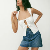 White linen crop top with tie-front detail and wide straps, paired with denim mini skirt — Reformation | Endless UAE