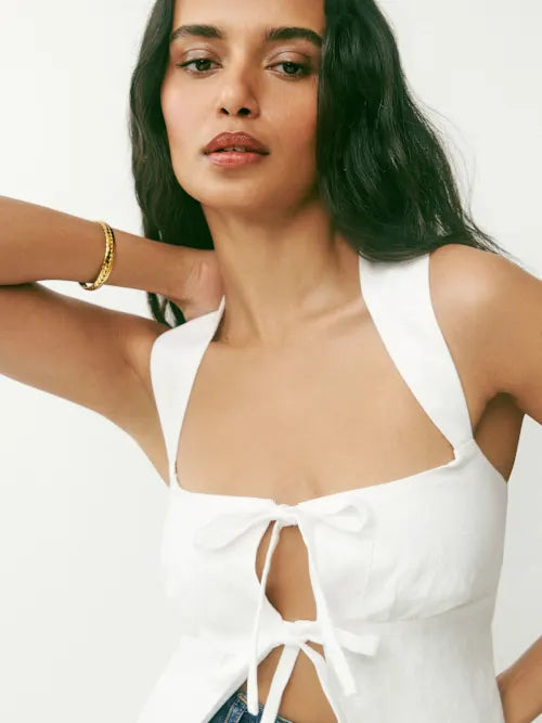 White linen halter top with front tie details and cutout design on model — Reformation | Endless UAE
