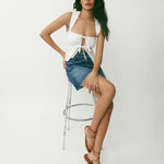 White linen halter top with tie-front cutout detail paired with denim mini skirt and strappy tan sandals — Reformation | Endless UAE