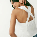 White linen halter top with crossed back straps and open back detail, styled with denim jeans — Reformation | Endless UAE