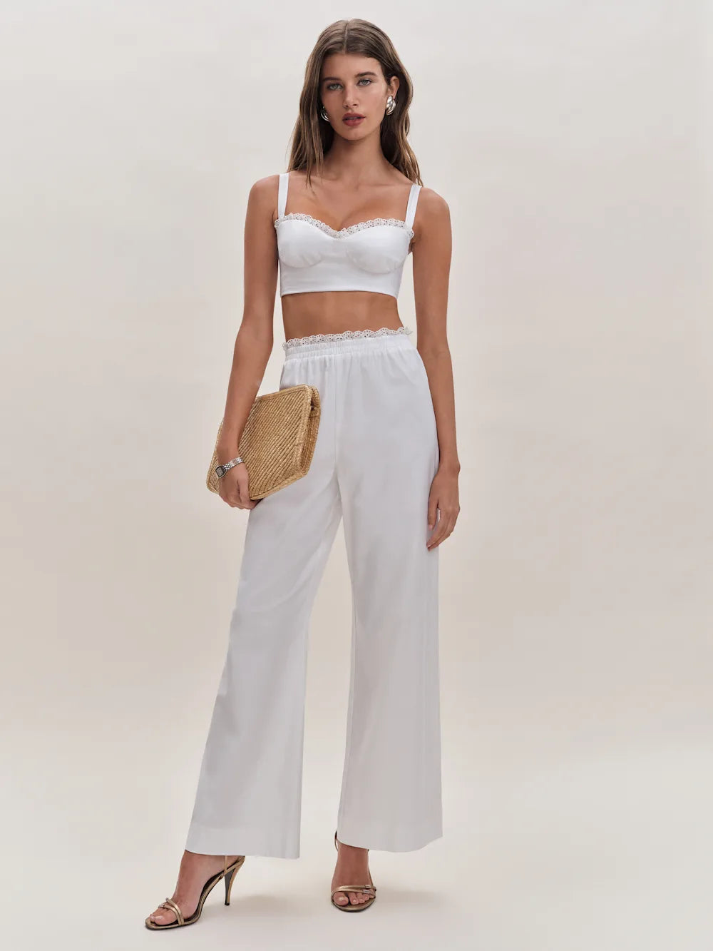 White lace-trimmed crop top and wide-leg pants two piece set with straw clutch and strappy heels — Reformation | Endless UAE