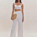 White lace-trimmed crop top and wide-leg pants two piece set with straw clutch and strappy heels — Reformation | Endless UAE