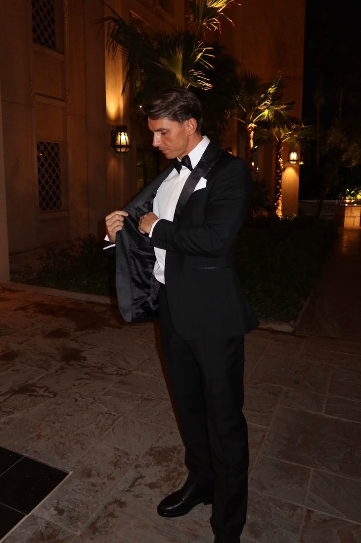 Man wearing black tuxedo trousers with white dress shirt and bow tie at formal event — Endless | Endless UAE