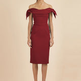 Woman wearing burgundy off-shoulder Tilly Pencil Dress with tied sleeves and black heels — The Pretty Dress Company | Endless UAE