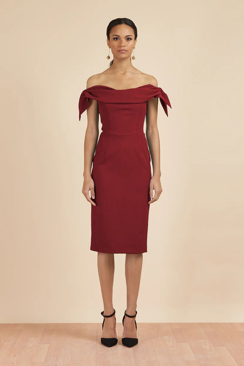 Woman wearing burgundy off-shoulder Tilly Pencil Dress with tied sleeves and black heels — The Pretty Dress Company | Endless UAE