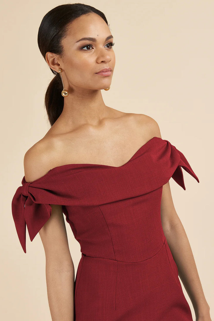 Woman wearing burgundy off-shoulder Tilly Pencil Dress with tied sleeves and black heels — The Pretty Dress Company | Endless UAE