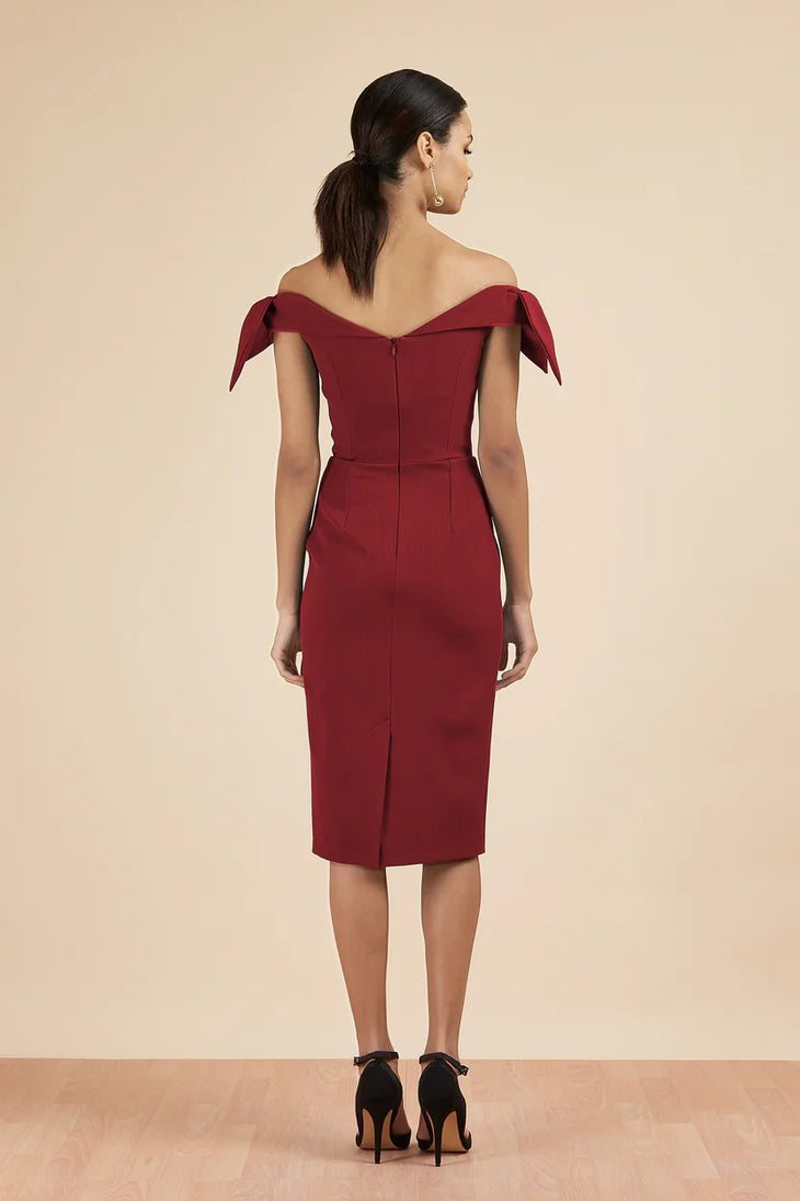 Woman wearing burgundy off-shoulder Tilly Pencil Dress with tied sleeves and black heels — The Pretty Dress Company | Endless UAE
