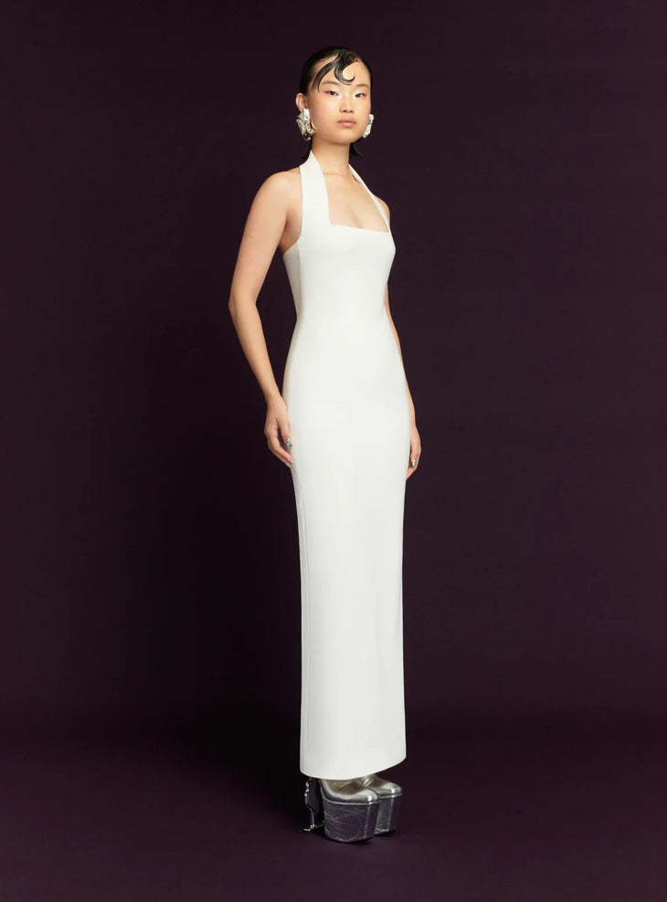 Elegant white halter neck maxi dress with fitted silhouette and floor-length hem on model — Solace London | Endless UAE