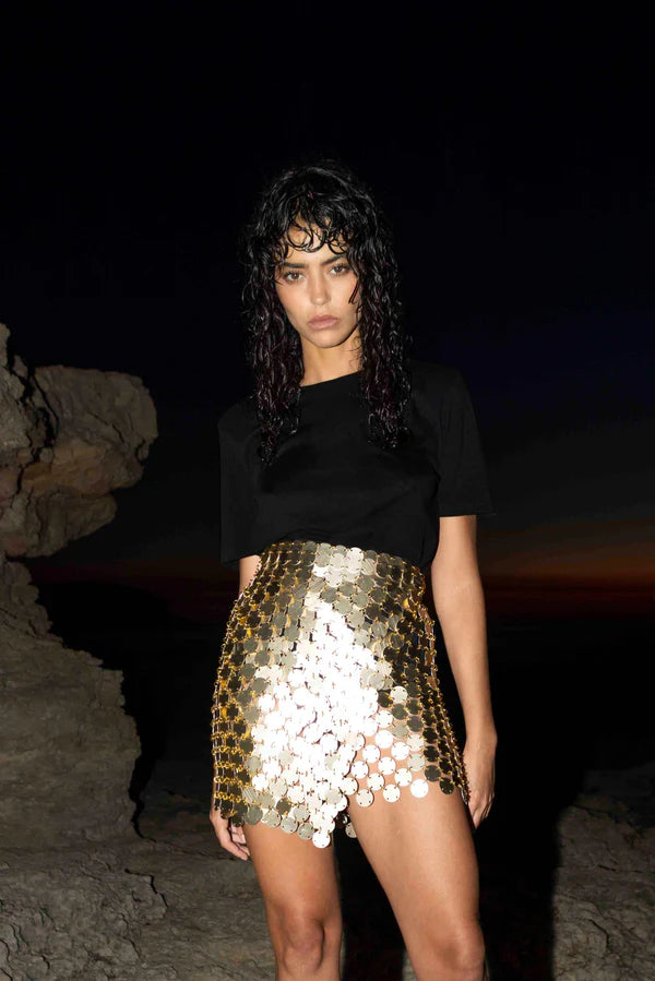 Gold sequin mini skirt with white accents worn with black crop top — Isabel Moore | Endless UAE