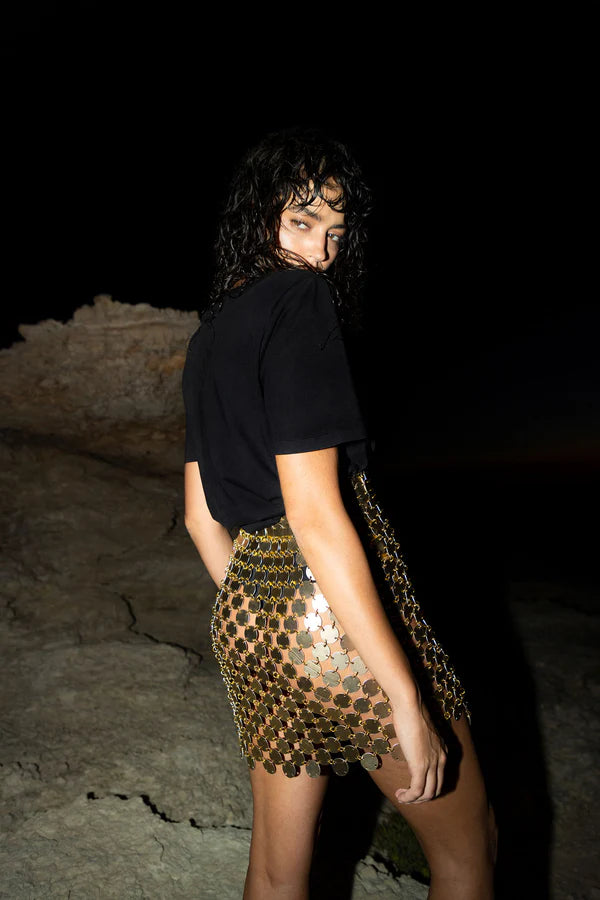 Gold sequin mini skirt with white accents worn with black crop top — Isabel Moore | Endless UAE
