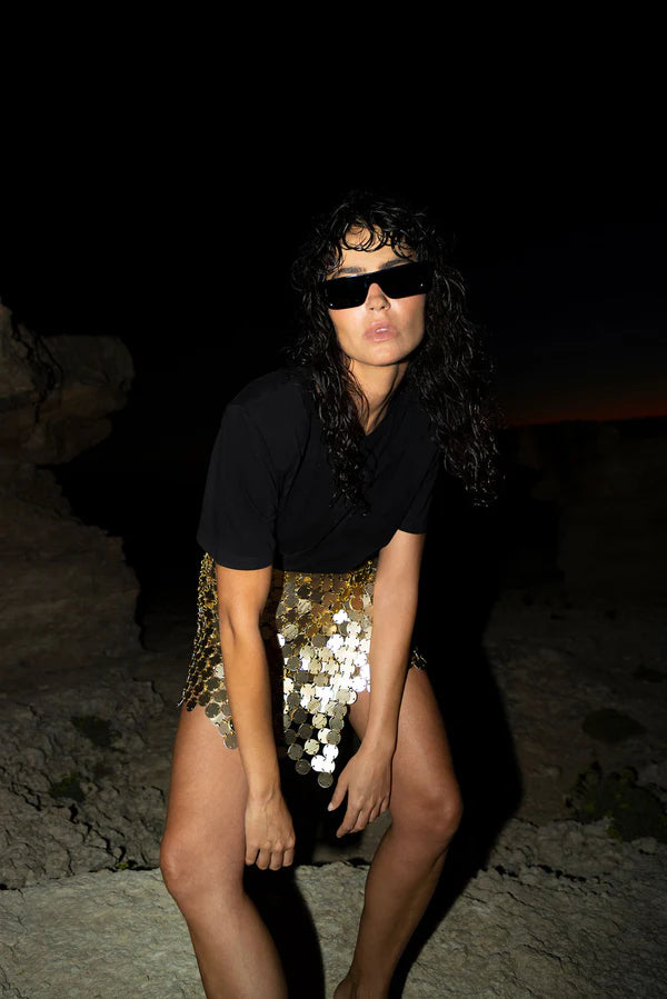 Gold sequin mini skirt with white accents worn with black crop top — Isabel Moore | Endless UAE