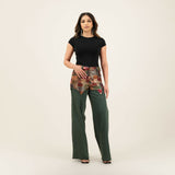 Woman wearing black top with patchwork embellished belt detail and green wide-leg denim pants — Quab | Endless UAE