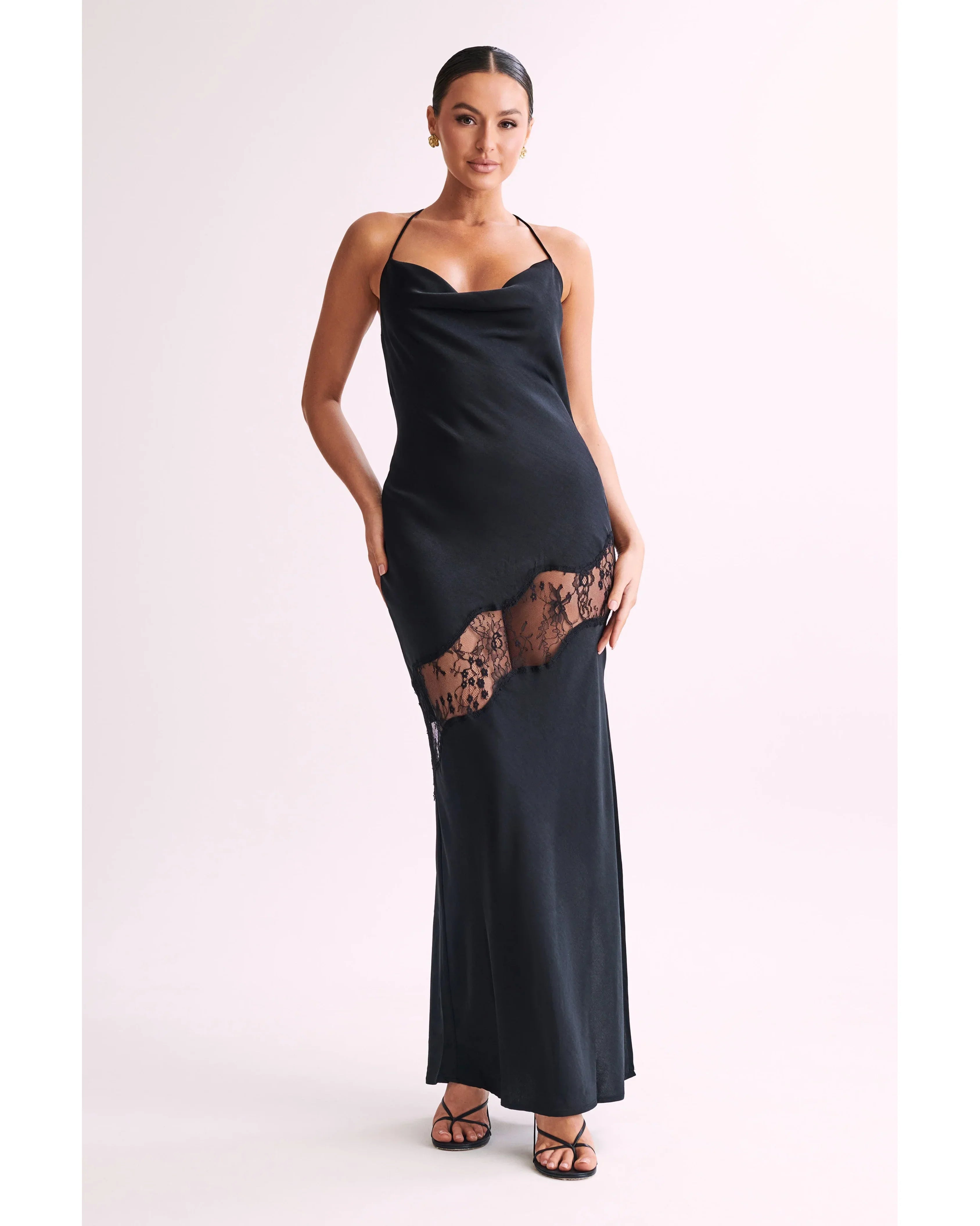 Woman wearing black satin maxi dress with lace side detail and halter neckline — Meshki | Endless UAE