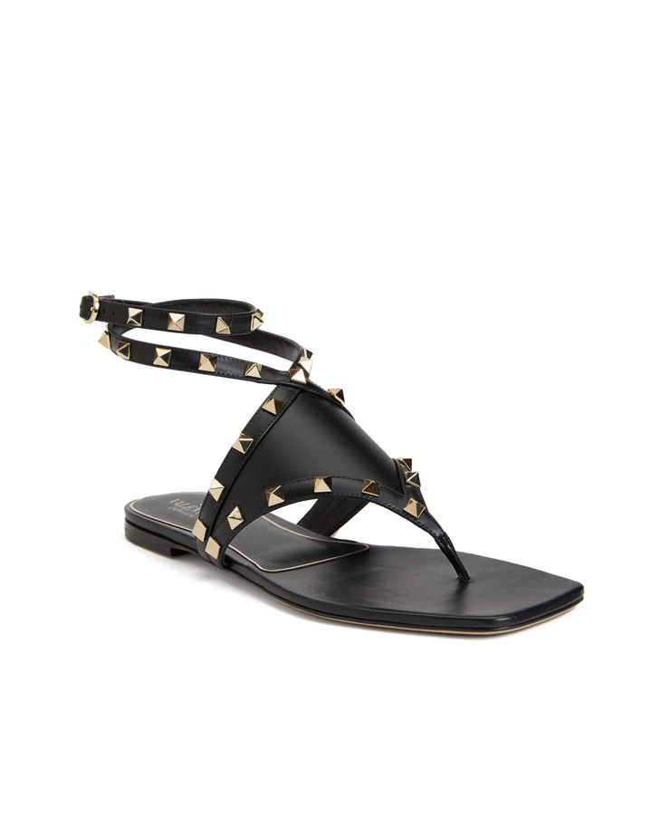 Black leather thong sandals with gold pyramid studs and ankle wrap strap — Valentino Garavani | Endless UAE