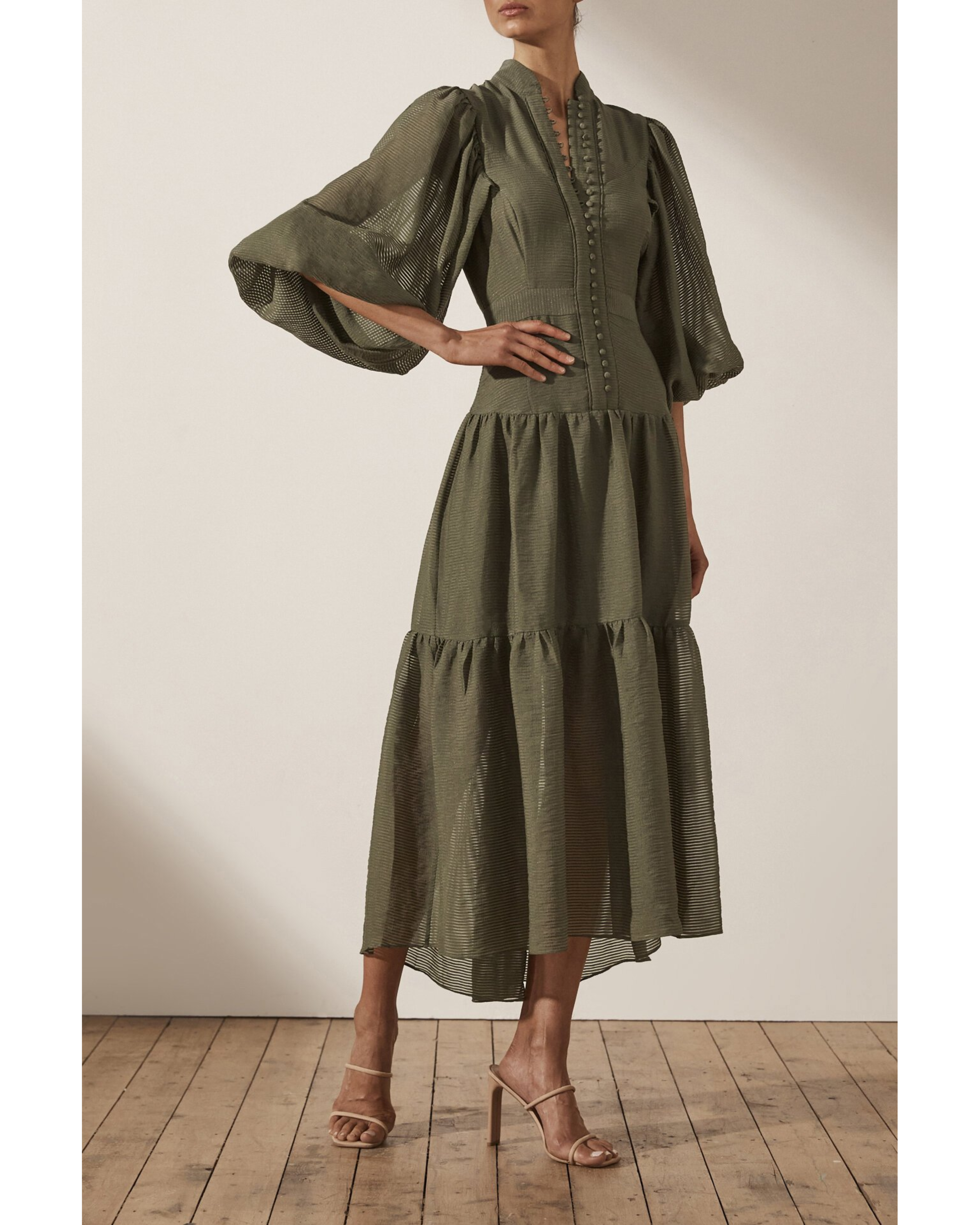 Olive green tiered midi dress with high neck, button front detail, and billowy long sleeves on model — Shona Joy | Endless UAE