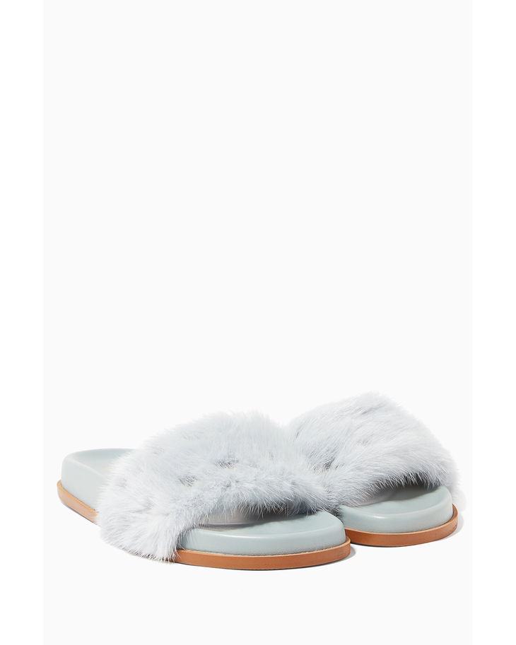 Light blue mink-fur slides with tan leather sole and footbed, shown from front angle — Valentino Garavani | Endless UAE