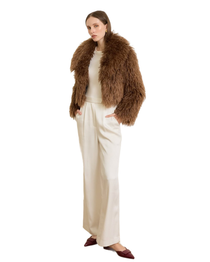Woman wearing camel-colored fur stole jacket over cream top and pants with burgundy shoes — Madame Magdalena | Endless UAE
