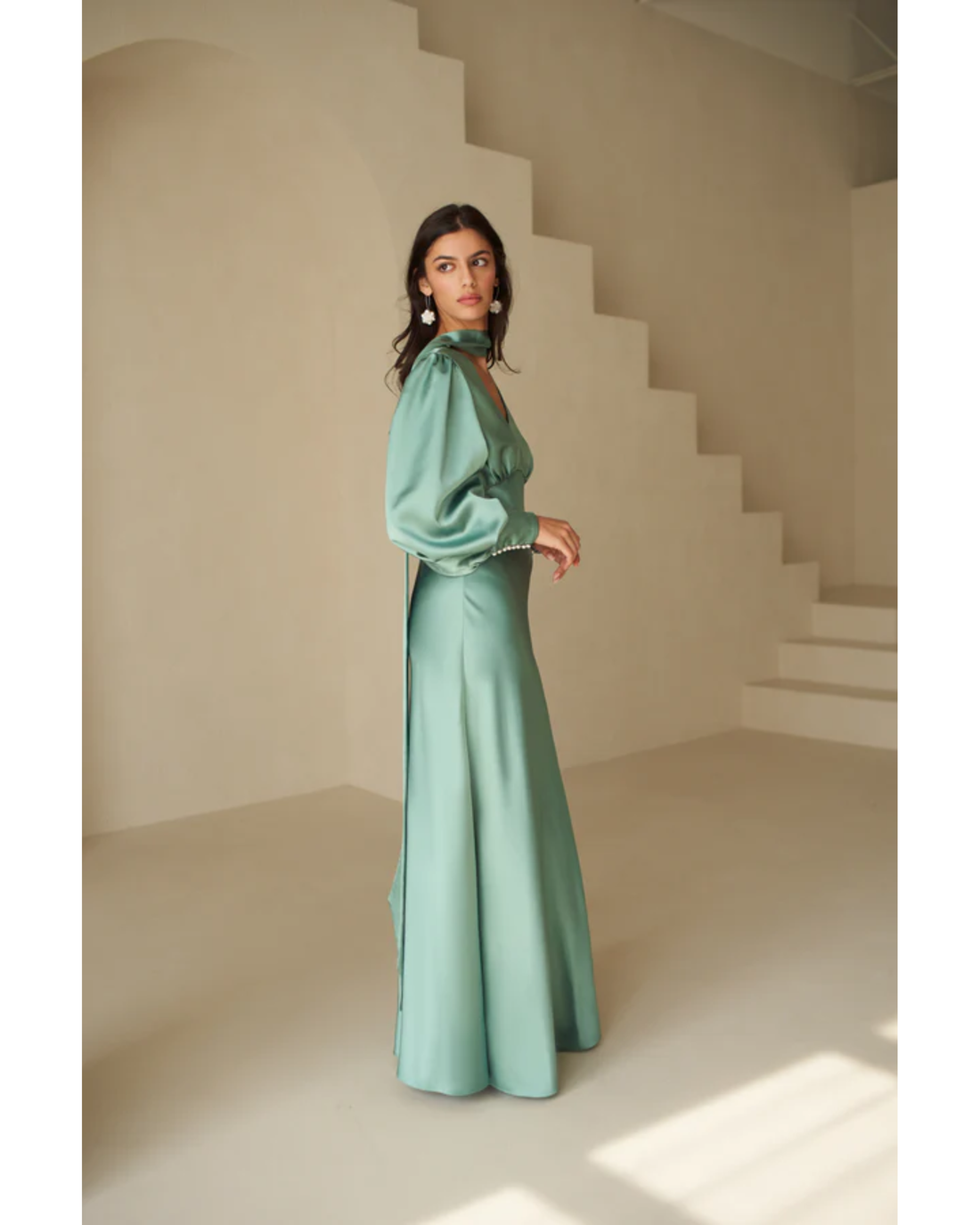 Woman in deep sea foam silky bias-cut gown with draped sleeve detail — Vasiliki | Endless UAE