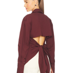 Burgundy poplin button-up shirt styled with cream trousers and black bag — Simon Miller | Endless UAE