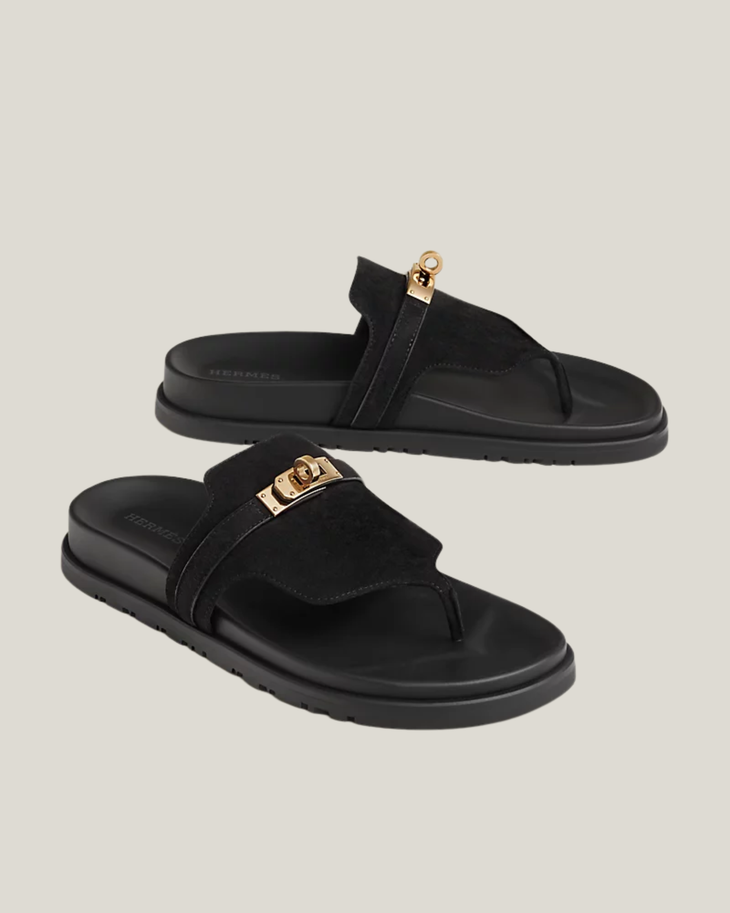 Black suede thong sandals with gold-tone turn-lock hardware and cushioned footbed — Hermes | Endless UAE