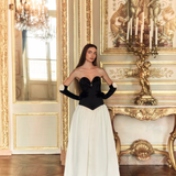 Woman wearing black and white off-shoulder Parisienne Maxi Dress in ornate palace room — Lichi | Endless UAE