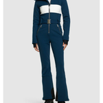 Woman wearing navy and white colorblocked ski jumpsuit with belt and black boots — Cordova | Endless UAE