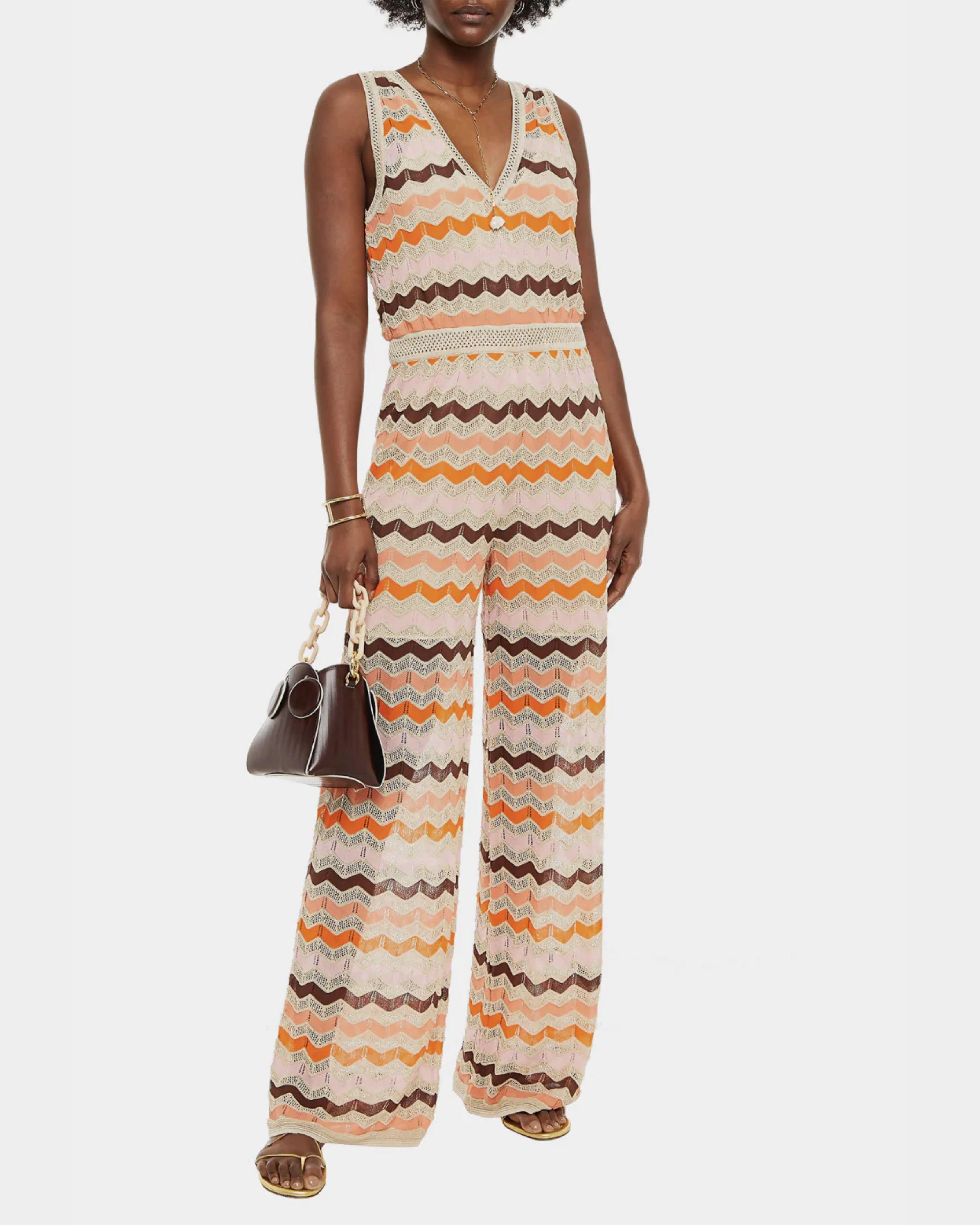 Woman wearing a colorful striped cotton jumpsuit with orange, brown and cream zigzag pattern — Missoni | Endless UAE