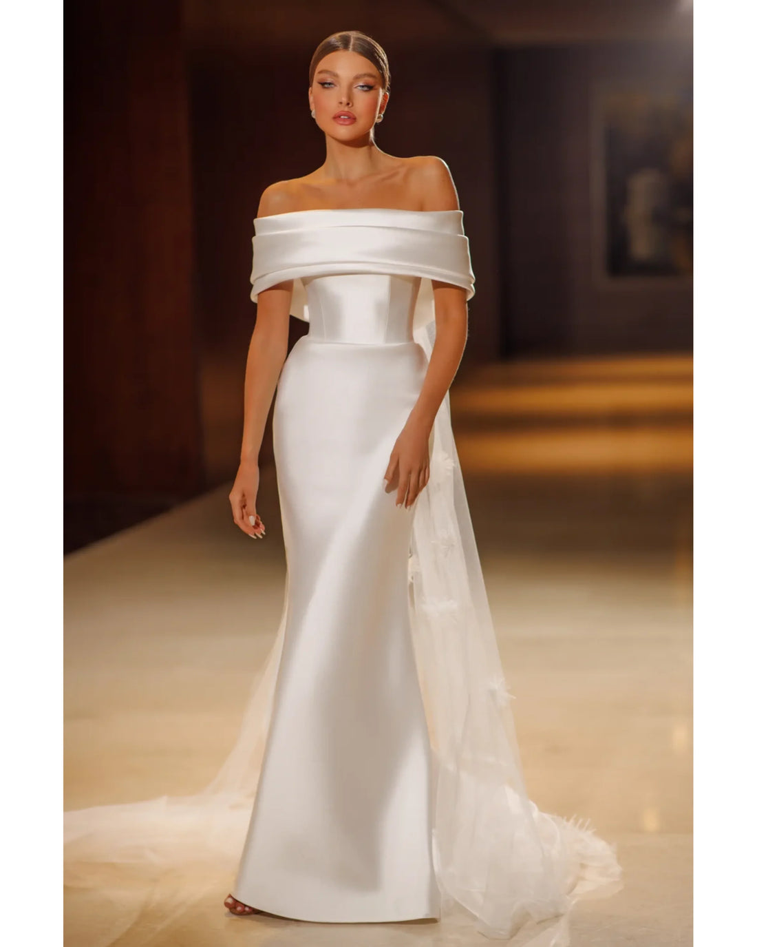 Elegant white off-shoulder mermaid gown with draped neckline and flowing train — Mary Trufel Boutique | Endless UAE