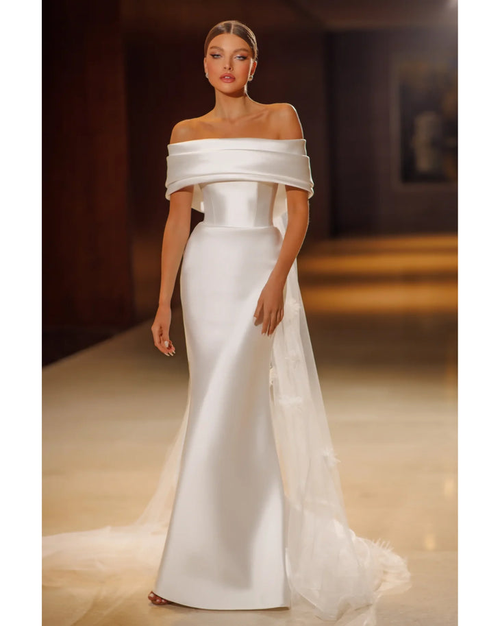 Elegant white off-shoulder mermaid gown with draped neckline and flowing train — Mary Trufel Boutique | Endless UAE