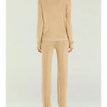 Woman wearing a beige metallic knit top and matching trousers holding a small handbag — SER.O.YA | Endless UAE