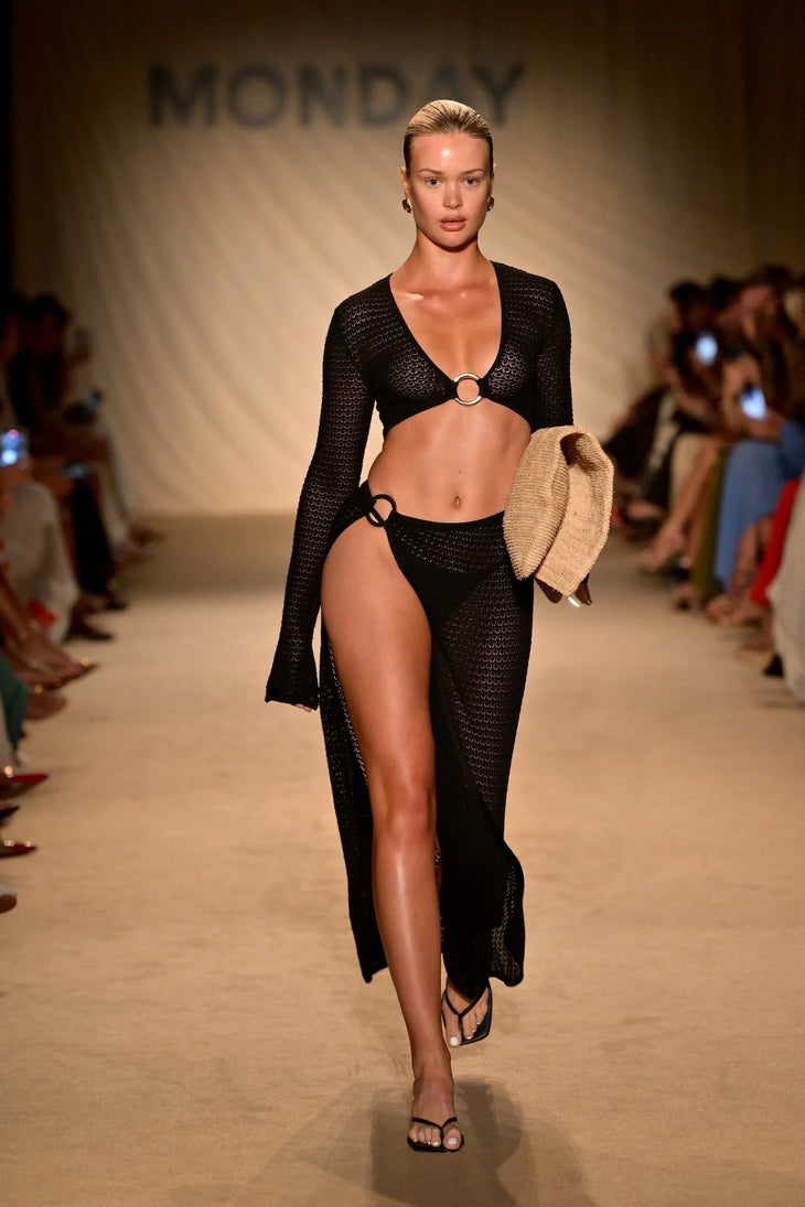 Black crochet maxi beach skirt with high slit worn over bikini bottoms on runway model — Mondays Swimwear | Endless UAE
