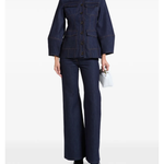 Woman wearing indigo denim jacket and flared jeans with white clutch — Florence & Fortitude | Endless UAE