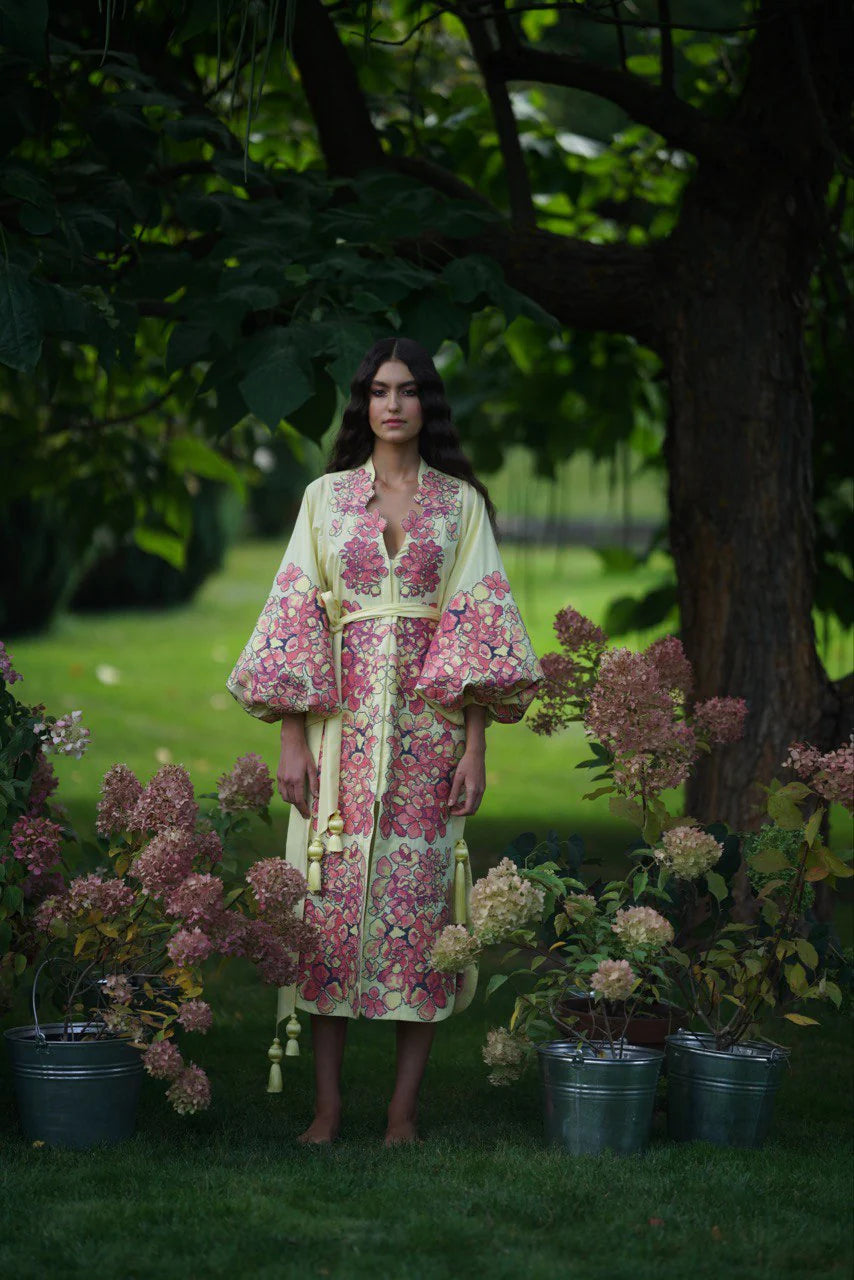 Hoertensia embroidered cotton caftan midi with pink floral pattern and balloon sleeves on model in garden — Yuliya Magdych | Endless UAE