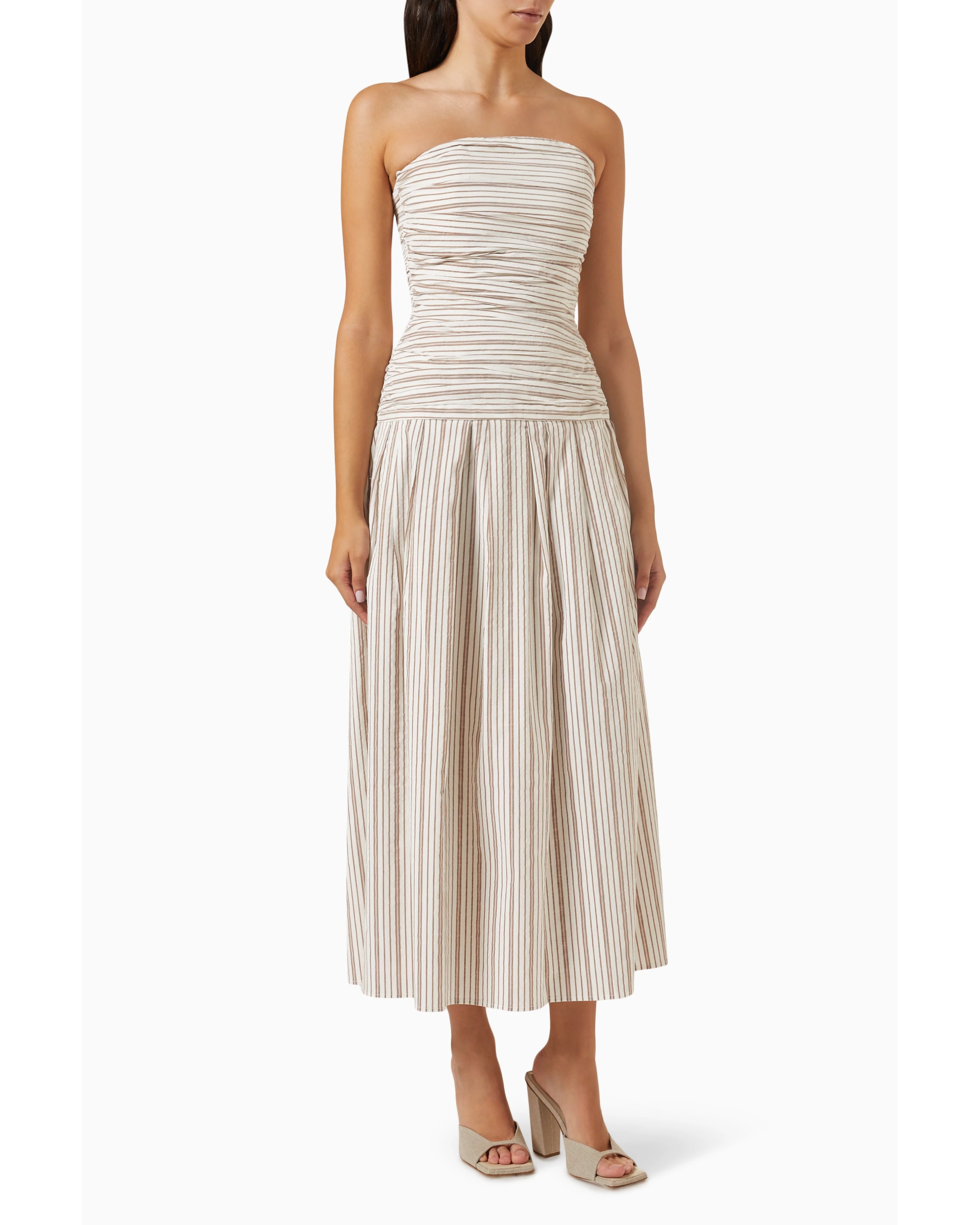 Woman wearing beige and white striped strapless midi dress with pleated skirt — Anna Quan | Endless UAE