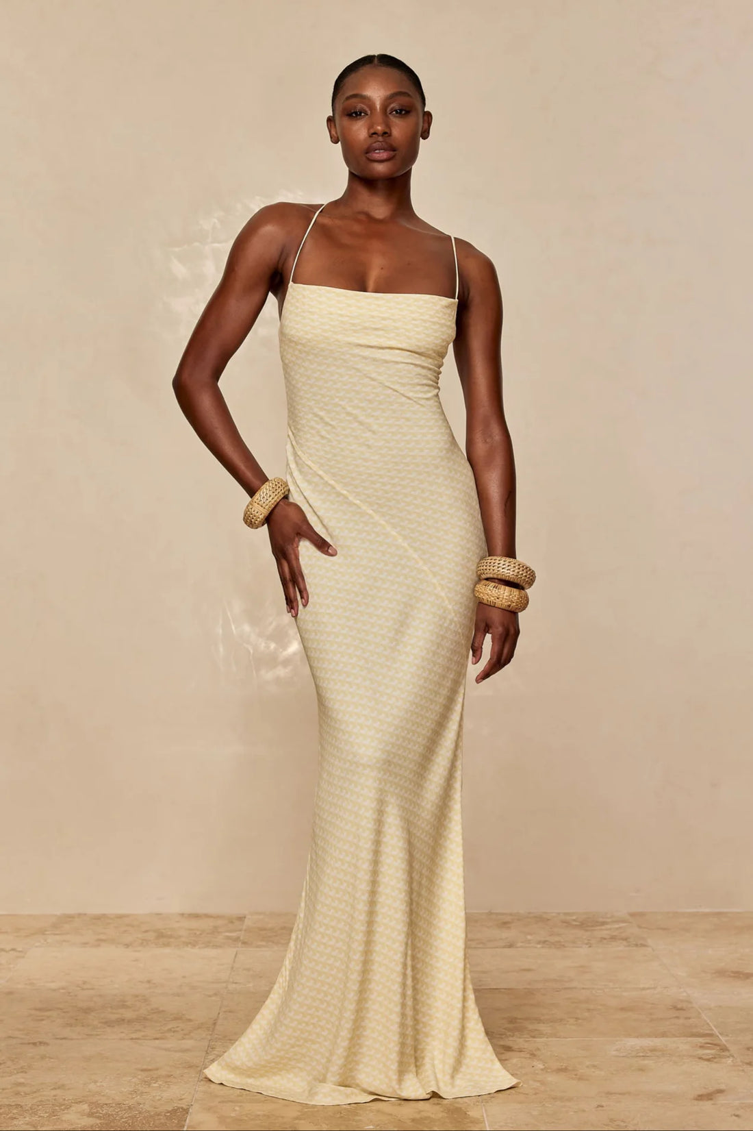 Elegant floor-length slip dress in champagne with thin straps and textured fabric, styled with gold bangles — Monday Swimwear | Endless UAE