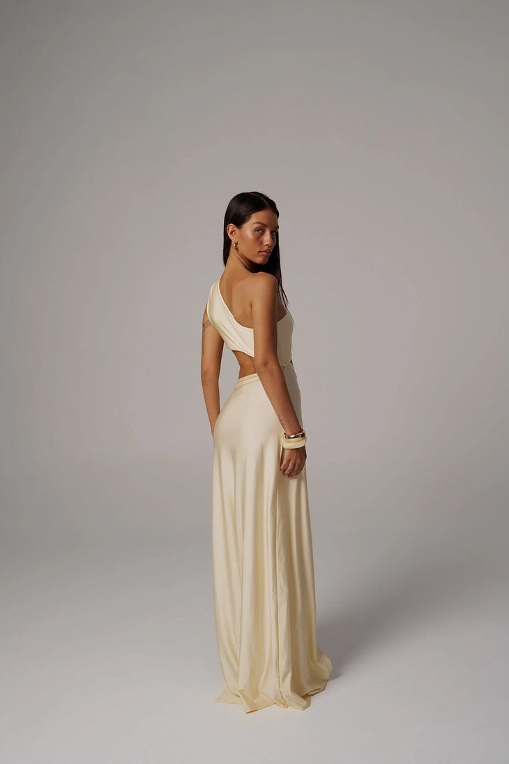 Woman wearing cream Scarlett one shoulder dress against green wooden door background — Sakuranna | Endless UAE